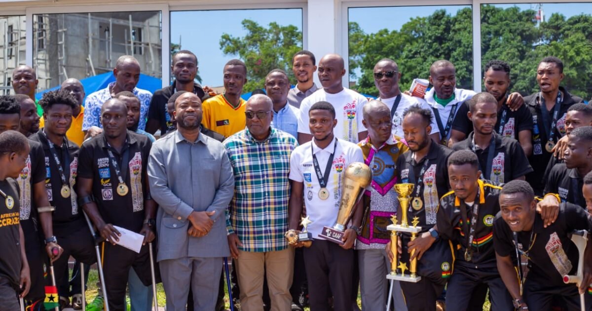 Group of men posing with medals and trophies after a sports awards ceremony outdoors