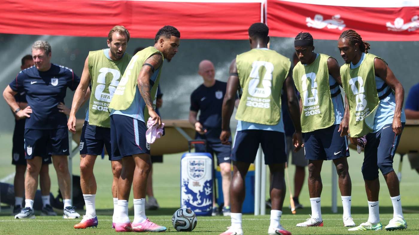 England national soccer team players in light green training bibs practicing on a sunny grass field with a ball at their feet during a training session
