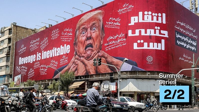Large red billboard with a close up of Donald Trump and the slogan Revenge is inevitable in English and Persian above a busy street with cars and motorcycles