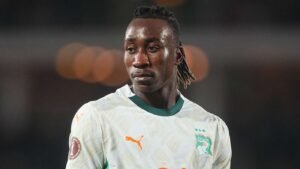 Soccer player in Ivory Coast national team jersey looking to the left on the pitch